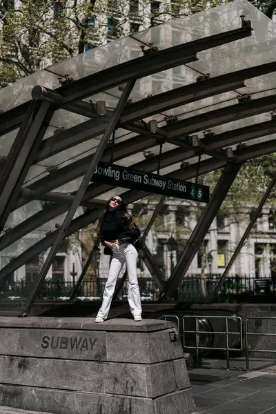 Şık bir insan New York metro girişinde kendine güvenerek poz veriyor, modayla canlı şehir hayatını harmanlıyor. New York 'lu Kadın.