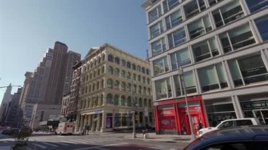 NEW YORK, ABD - 8 Aralık 2024: Canlı bir şehir sokak sahnesinde açık mavi gökyüzü altında tarihi ve modern binaların bir karışımı yer alıyor