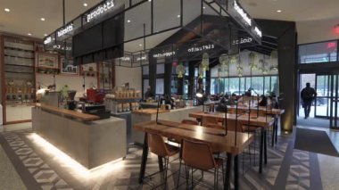 JERSEY ŞEHRİ, ABD - 2 Aralık 2024: Ahşap kirişler ve asılı bitkilerin yer aldığı şık bir restoran iç mekanı, yemek ve sosyal etkinlikler için ideal.