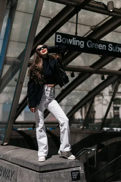 Şık bir insan New York metro girişinde kendine güvenerek poz veriyor, modayla canlı şehir hayatını harmanlıyor. New York 'lu Kadın.