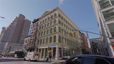 NEW YORK, ABD - 8 Aralık 2024: Canlı bir şehir sokak sahnesinde açık mavi gökyüzü altında tarihi ve modern binaların bir karışımı yer alıyor