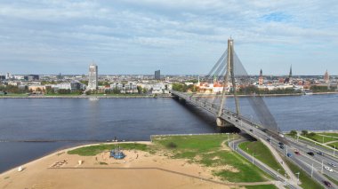 Daugava Nehri Taş Köprüsü Akmens, kumsaldan, sahil transferi arabalarından, Riga rıhtımından, havadan, havadan, ünlü Rigas limanı tarihi liman Rigas şehri, Panorama 'daki Letonya jet nakliyatından geçiyor.