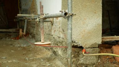 Evin duvarının altını oymak, binayı nemli şömineye karşı kesip yalıtmak. Profesyonel su yalıtımı ve elmas bir iple tuğla bir duvara bağlanma, elektrikli testere.