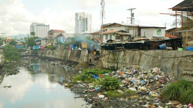 Filipinler gecekondu mahallesindeki fakir nehir atıkları çöplükleri atık çöplükleri kirlilik atık çöplükleri yoğun nüfuslu insanlar aç insanlar aile yoksulluğu Cebu Mandaue Şehri 'nin kirli çöplükleri çöplük kulübelerinden geçen çöplük