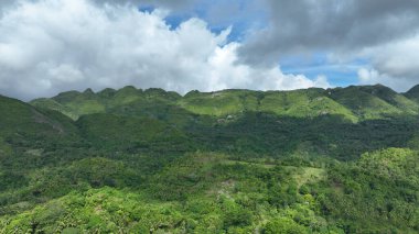 Orman tropikal dağı Manghilao Corte, Cebu drone hava aracı Filipinler egzotik biyolojik çeşitlilik doğa koruma bitkileri ve hayvanlar, endemik türler dağlar doğa mavi gökyüzü bulutları ve köy Triumfo insanları şeker kamışı tarlası
