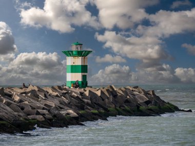 SCHENINGEN, NETHERLANDS - 11 Ocak 2021: Scheveningen limanının girişinde yeşil beyaz fenerli güney iskelesi, Lahey