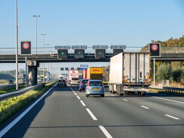 GELDERLAND, NETHERLANDS - OCT 28, 2021: Trafik, hız sınırı işaretleri ve A1 otoyolunda yeşil okları olan şerit matris işaretleri kullan