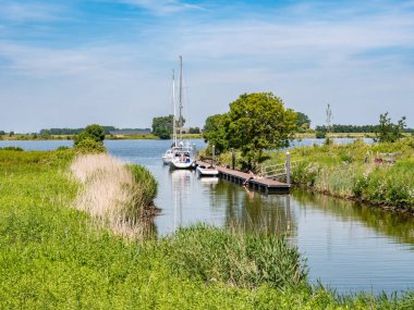 TIENGEMETEN, NETHERLANDS - 15 HAZİRAN 2022: Güney Hollanda, Haringvliet 'teki Tiengemeten adasında iskeledeki botlu küçük liman