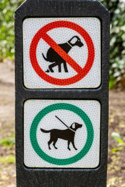 Köpekler için dışkılama yasağı olan piktogramlar ve orman, Hilversum, Hollanda 'da köpeklere tasma takılmış olmalı.