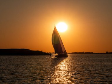Tholen ve Sint Filipsland, Oosterschelde Ulusal Parkı, Zeeland, Hollanda arasındaki Krabbenkreek körfezinde gün batımında yelkenliyle yelken açmak.