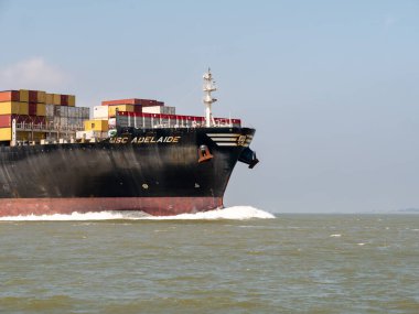 BatıSKASI, NETHERLANDS - 21 Haziran 2023: Hollanda 'daki Westerschelde limanında Belçika' nın Antwerp limanına doğru yol alan konteyner gemisi MSC Adelaide 'ın pruvası