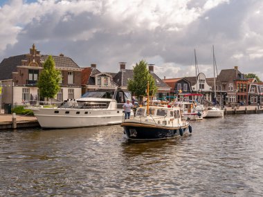 LEMER, NETHERLANDS - 2 JUL 2023: Hollanda 'nın eski Lemmer kentindeki Het Dok Kanalı' nda demirleme yeri arayan motorbot