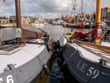 LEMMER, NETHERLANDS - 2 Temmuz 2023: Hollanda 'nın eski Lemmer kentindeki Binnenhaven kanalında geleneksel ve modern tekneler