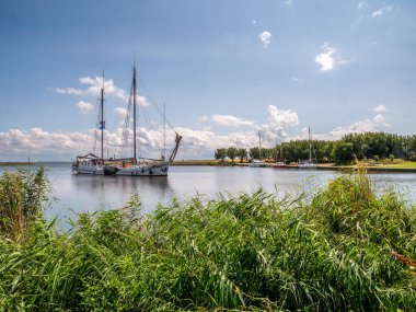 TRINTELHAVEN, NETHERLANDS - 12 JUL 2023: İki direkli yelkenli gemi Lelystad ve Enkhuizen, Hollanda arasındaki Houtribdijk 'te Trhaven' a sığınıyor