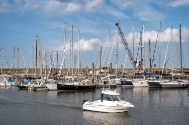 AMELAND, NETHERLANDS - 14 AUG 2023: Wadden Denizi 'ndeki Batı Frizya adası Ameland' daki Waddenhaven Marina 'da sürat teknesi ve yelkenli tekneleri