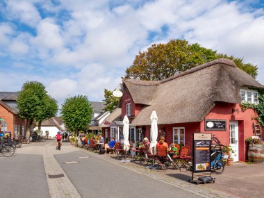 Amrum, Germany - Aug 26, 2023: Street with outdoor cafes in old town of Nebel, Amrum island, North Frisia, Schleswig-Holstein clipart