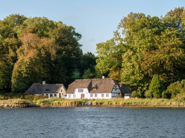 Middelosart, Danimarka - 25 Şubat 2023: Hindsgavl, Güney Danimarka 'da Faenosund boyunca sazdan çatılı eski bir balıkçı evi