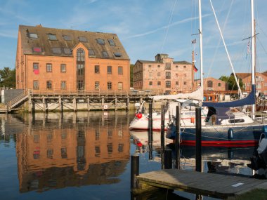 Orth, Germany - Sep 2, 2024: Warehouses and boats in Orth harbour on Fehmarn Island in Baltic Sea, Schleswig-Holstein clipart