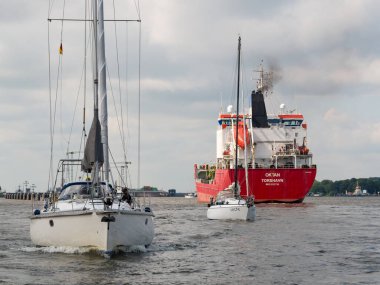 Kiel Canal, Germany - Jul 16, 2024: Sailing boats passing chemical tanker cruising on Kiel Canal near Brunsbuttel clipart