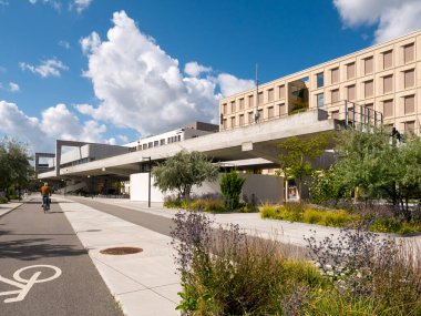 Kopenhag, Danimarka - 10 Ağustos 2024: Nordhavn 'da Orientkaj Metro İstasyonu' nun yanındaki bisiklet yolu boyunca bisiklet süren bisikletçi