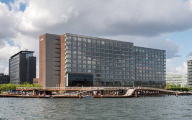 Kopenhag, Danimarka - 10 Ağustos 2024: Vesterbro 'daki Marriott Oteli' nin önündeki Kalvebod rıhtımında gezinen ve dinlenen insanlar