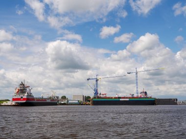 Delfzijl, Hollanda - 7 Temmuz 2024: Handelshaven, Eemsdelta, Groningen 'deki Delfzijl ticaret limanında kargo gemisi taşıyan tersane