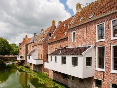 Appingedam, Netherlands - Jul 8, 2024: Canal houses with hanging kitchens over Damsterdiep canal in historic town of Appingedam, Eemsdelta, Groningen clipart