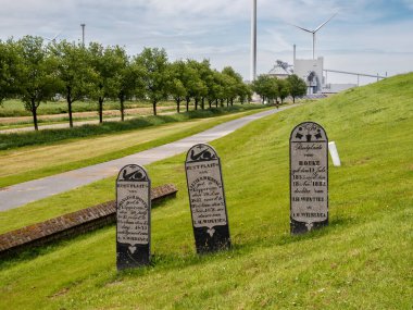 Delfzijl, Netherlands - Jul 9, 2024: Graves from the former cemetery of the disappeared village Oterdum are a memorial on the seawall south of Delfzijl, Eemsdelta, Groningen clipart