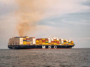 North Sea, Germany - Jul 15, 2024: Container ship MSC Azov emitting smoke while heading for Elbe, German Bight clipart