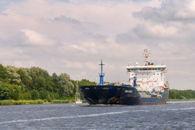 Kiel Kanalı, Almanya - 16 Temmuz 2024: Kimyasal petrol tankeri Songa Atlantik Kiel Kanalı 'nda küçük yelkenli teknesini geçiyor, Schleswig-Holstein