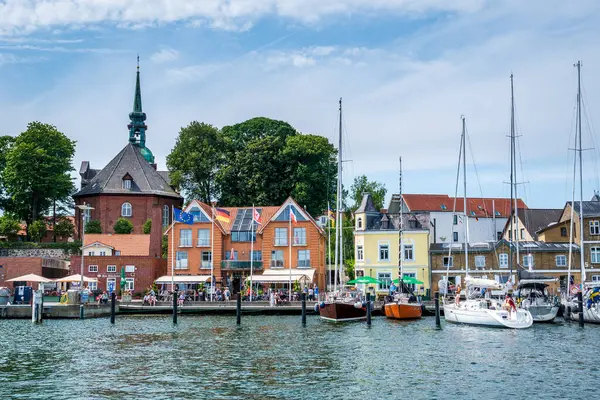 Kappeln, Almanya - 21 Temmuz 2024: Rıhtımda tatilin tadını çıkaran yelkenliler ve insanlar Kappeln, Holstein-Holstein eyâletinde