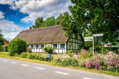 Fejo, Denmark - Aug 4, 2024: Old half-timbered brick cottage with thatched roof on Fejo Island, Zealand region clipart