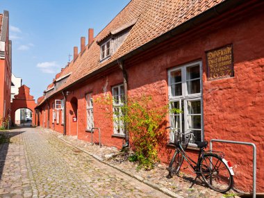 Stralsund, Almanya - 20 Ağustos 2024: Tarihi kırmızı tuğlalı evler ve Heilgeistkloster, Kutsal Ruh Manastırı 'nda kemerli dar sokaklar, Mecklenburg-Vorpommern