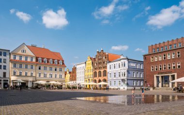 Stralsund, Almanya - 20 Ağustos 2024: Renkli Barok ve Tuğla Gotik şehir evleri olan eski pazar meydanı, Stralsund, Mecklenburg-Vorpommern