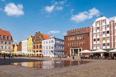 Stralsund, Almanya - 20 Ağustos 2024: Renkli Barok ve Tuğla Gotik şehir evleri olan eski pazar meydanı, Stralsund, Mecklenburg-Vorpommern
