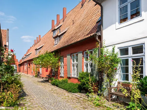 Stralsund, Almanya - 20 Ağustos 2024: Tarihi tuğla evler ve Heilgeistkloster, Kutsal Ruh Manastırı 'ndaki kemer yolu ile dar sokak sahnesi, Mecklenburg-Vorpommern