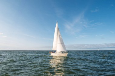 Wadden Denizi, Almanya - 14 Şubat 2024: Wadden Denizi, Aşağı Saksonya, mavi gökyüzünün altında beyaz yelkenliler, UNESCO Dünya Mirası sahasında boş zaman aktiviteleri