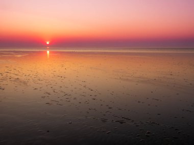 Hollanda, Friesland açıklarında geniş gelgit düzlükleri, sakin Unesco Wadden Denizi üzerinde gün batımı