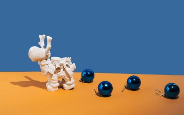 Mavi sarı arka planda ren geyiği ve mavi Noel baloncukları. Yeni yıl ve Noel konsepti. Düz yatıyordu. Üst görünüm