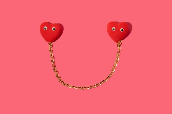 Two heart connected with golden chain on red background.St.Valentine\'s concept idea