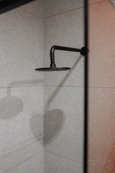 콘크리트 흰색의 그늘이있는 욕실에서 직사각형 정착물 헤드의 스톡 이미지