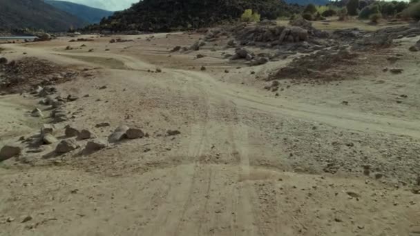 史诗般的无人驾驶飞机拍摄的冒险摩托车骑在沙漠 在沙滩沙丘或山中的小径或砾石路上的越野摩托车 有趣而令人兴奋的摩托车探险 — 图库视频影像