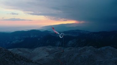 Kırılmış ve parçalanmış rüzgârlı çorap, dağın tepesinde güçlü rüzgarda uçmak. Yükseklikte meteoroloji istasyonu. Kasvetli ve tehlikeli hava. Dağ manzarası üzerinde güçlü fırtına