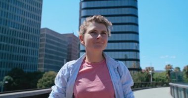 Otantik, havalı genç bir kadının portresi güneşli yaz gününde şehirde elektrikli scooter kullanıyor. Ortak ekonomi kavramı, büyük şehirde kentsel hareketlilik, son kilometre ulaşım