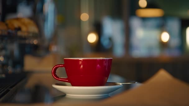 バーやカフェでコーヒーエスプレッソマシンの隣のバーカウンターには 熱い飲み物を蒸しの大皿に小さな赤いカップが立っています アメリカン ダイナーでアメリカーノやブラックコーヒーを蒸し — ストック動画