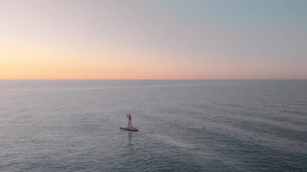 一个人在开阔的海洋中漂浮在桨板上 这景象令人震惊 站在Sup董事会上沉思 专注的体育活动 — 图库视频影像