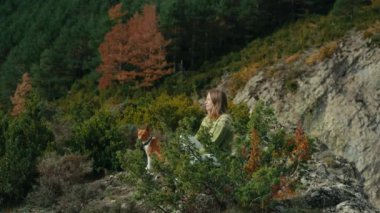 Woman with dog sit on the hill surrounded by nature. Peaceful inspiring moment, relax after hike. Happy outdoor life in Europe. Meditation concept.