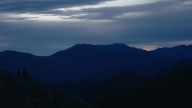 Landscape scenery of dusk sunset in mountains. Majestic blue sky and clouds over beautiful tops of the hills. Dramatic sunset or sunrise moment 