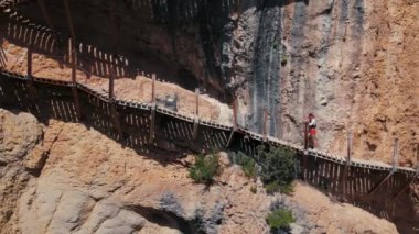 Woman climb the stairs to top of cliff on hot summer vacation day. Remarkable moment, dangerous adventure. Breathtaking view of rock in Europe.