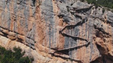 Drone shot of approaching young female rock climber in the middle of cliff. Adventure for tourists on summer vacation in Europe. 